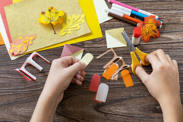 Instruction step 9. Thanksgiving craft bookmark turkey paper on a wooden table. Childrens art...