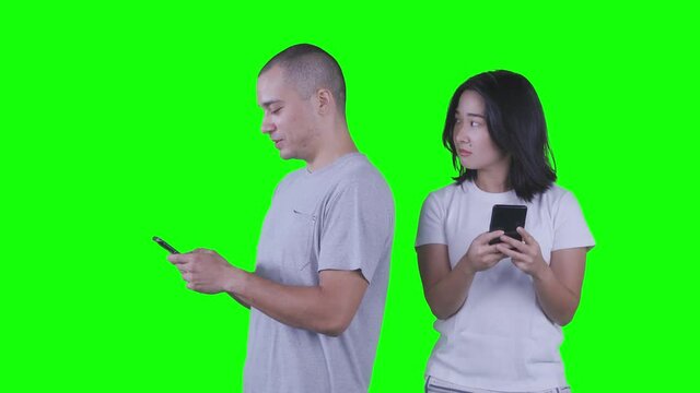 Woman spying at mobile phone of her husband