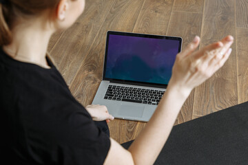 the trainer conducts yoga classes in front of the laptop