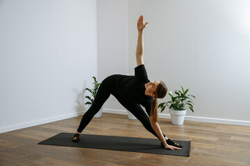 girl in black doing yoga on a light background yoga studio