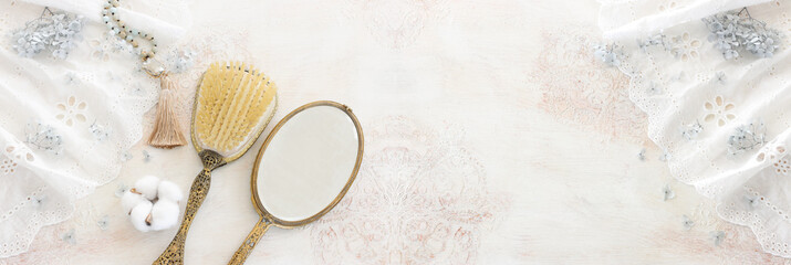 Background of white delicate lace fabric, neckless and vintage hand mirror