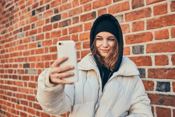 Young woman having video call, talking remotely, taking selfie photo