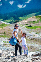Woman with her daughter along a mountain trail in summer season,