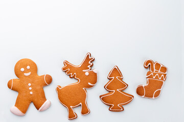 Gingerbread man, cookies and Christmas decor on pastel background.