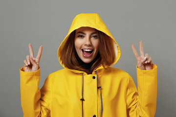 Happy caucasian girl in yellow raincoat with hood