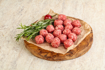Raw uncooked beef meatballs served rosemary