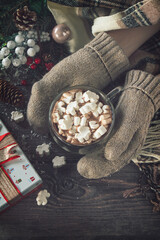 Winter concept. Hot chocolate cacao drink with marshmallows and Christmas present on a wooden table. Top view flat lay background.