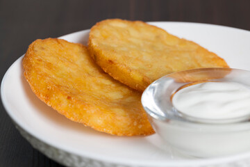 potato pancakes with sour cream on a plate