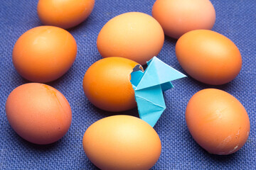 Broken eggs and paper bow ties on a plain background