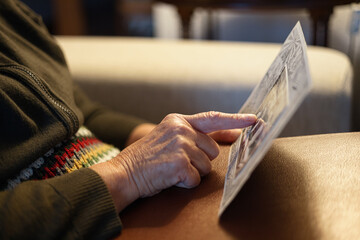 Old woman looking at vintage family photo