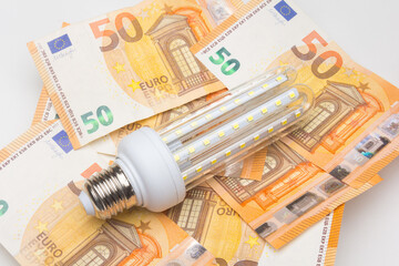 Banknotes and light bulbs on top of the money
