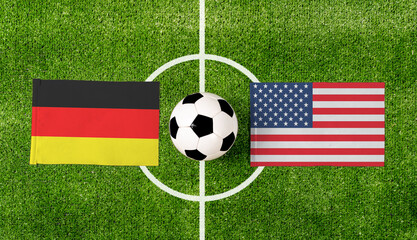 Top view soccer ball with Germany vs. USA flags match on green football field.