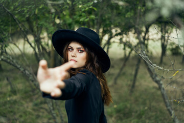 woman in a black hat gesturing with her hands witch magic fantasy