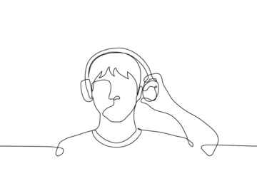 man in On-Ear headphones left earphone from being pulled from the ear - one line drawing vector. concept man in headphones interrupted listening to music to hear the sound outside