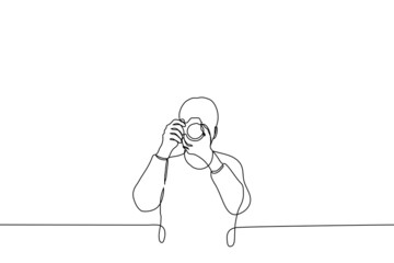 man stands with camera taking pictures of the viewer - one line drawing vector. concept of amateur or professional photographer, journalist reporter