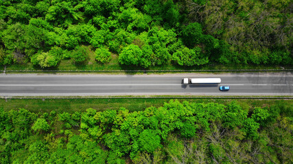 Aerial. Overtaking a truck by a passenger car. Top view from drone. - obrazy, fototapety, plakaty