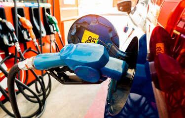 Car fueling at gas station. Refuel fill up with petrol gasoline. Petrol pump filling fuel nozzle in fuel tank of car at gas station. Petrol industry and service. Petrol price and oil crisis concept.