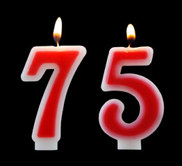 Red birthday candles isolated on black background, number 75