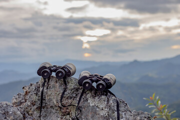 binoculars on top of rock mountain at sunset