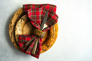 Overhead view of cutlery and a napkin in a napkin ring on a plate