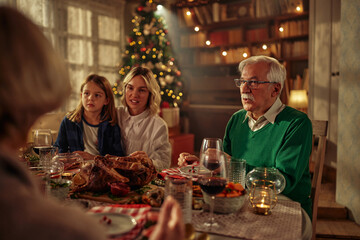 Boy, mother and grandfather at the table celebrating Christmas