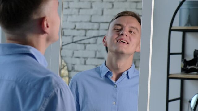 Young man tune in to positive looking in the mirror. Self-esteem concept