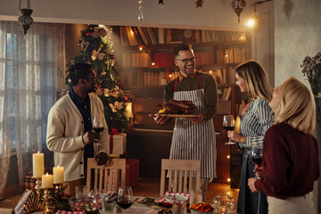 Four diverse people enjoying Christmastime together at home with delicious food