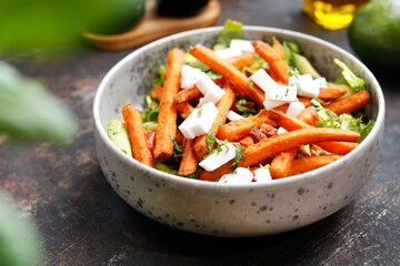 Sweet potato fries on green lettuce.
Appetizing dish. Culinary photography, a proposal to serve a meal.