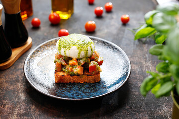 Bruschetta with burrata and basil pesto.
Appetizing dish. Culinary photography, a proposal to serve a meal.