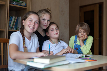 Fototapeta na wymiar Four girls at desk with notebooks and books