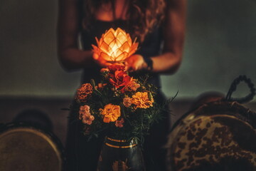 beautiful meditating woman with lotus candle in her hand and dje