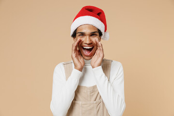 Young african man in Santa Claus red Christmas hat scream hot news about sales discount with hands...