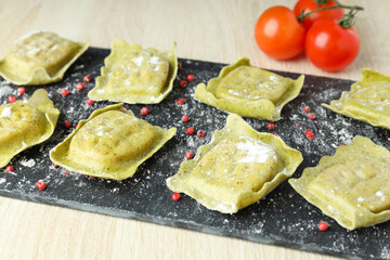 Concept of cooking ravioli on wooden background