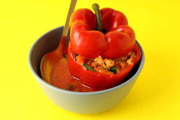 Stuffed pepper in bowl on yellow background