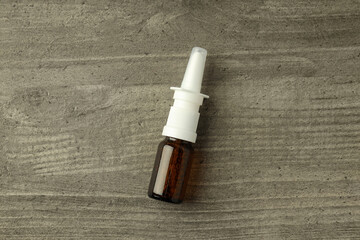 Blank bottle of nasal spray on gray textured background