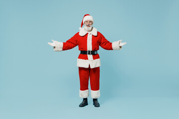 Fototapeta na wymiar Full body confused old Santa Claus man 50s wear Christmas hat red suit clothes spread hands isolated on plain blue background studio. Happy New Year 2022 celebration merry ho x-mas holiday concept
