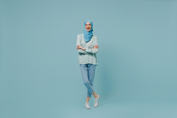 Full body young arabian asian muslim woman in abaya hijab hold hands crossed folded look camera...