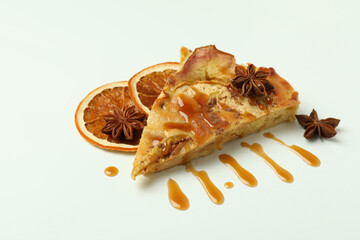 Piece of apple pie with caramel on white background