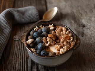 Gluten free breakfast bowl with greek yogurt, pureed pumpkin, blueberries and smashed brown rice cracker