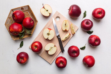 Naklejka na ściany i meble Fresh red apples with green leaves on table. cutting board with knife. Top view