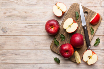 Fresh red apples with green leaves on table. cutting board with knife. Top view
