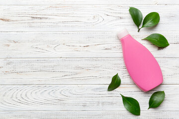 Obraz premium Organic cosmetic products with green leaves on wooden background. Copy space, flat lay