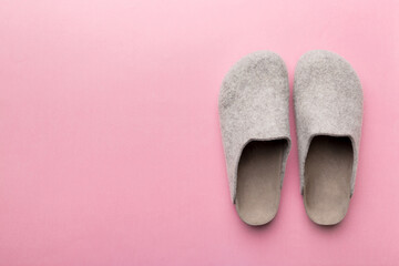 Warm winter women woolen slippers on colored background. Copy space for text