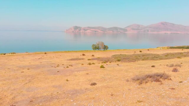 Aerial approaching view scenic blue lake panorama with island on horizon . Armenia Sevan peninsula landscape lake coastline