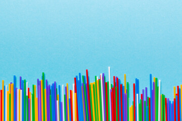 Heap of colorful plastic drinking straws on Colored background, flat lay. Copy Space for text