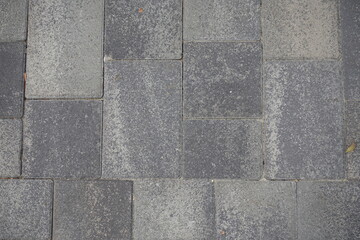Dry surface of pavement made of rectangular gray concrete blocks