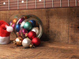 Colorful Christmas balls in glass with a fingerboard of an electric guitar, Christmas music or holidays concept