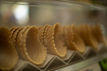 Waffle cones for ice cream. Sweets on the shop window.