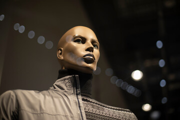 A dark skin color mannequin. The figure of an African man in a jacket. Autumn collection of clothes. Shop window.