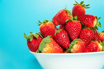 freshly picked organic strawberry isolated over blue background, healthy eating. 